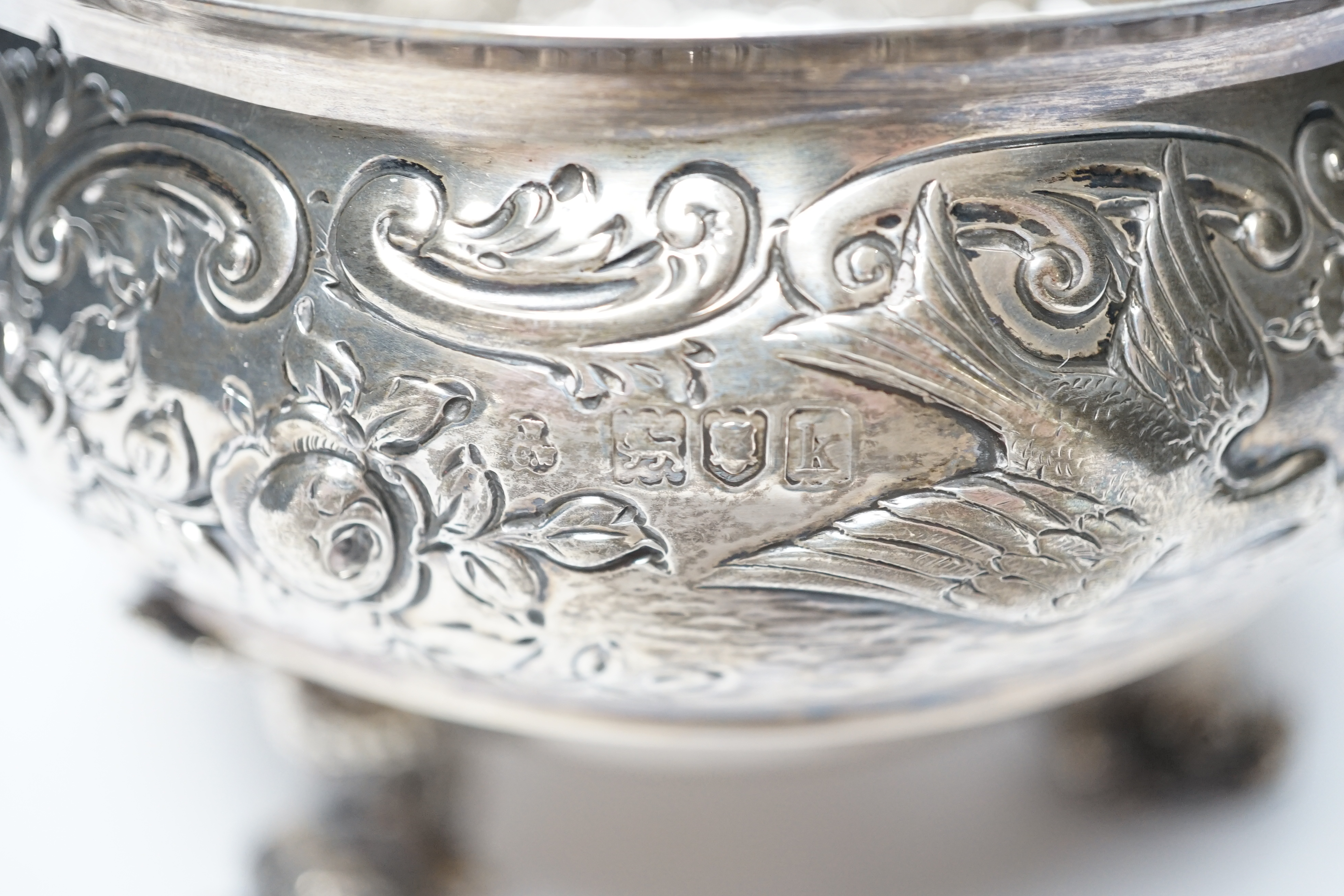 An Edwardian embossed silver bowl, on three dolphin supports, Wakely & Wheeler, London, 1905, diameter 11.6cm, 11.4oz.